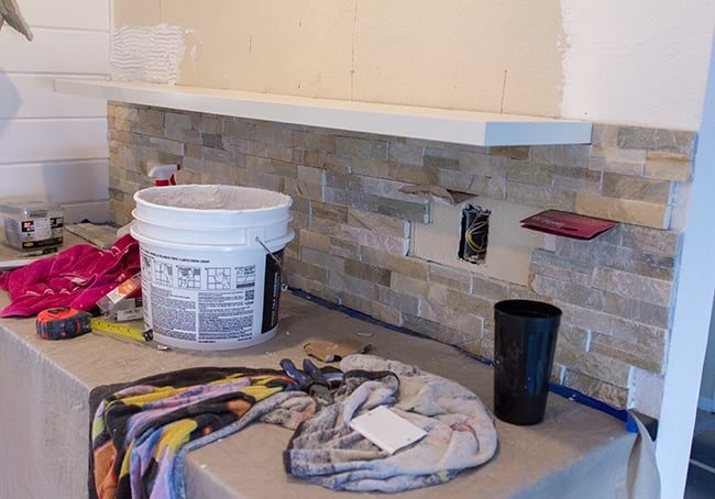 diy quartz ledgestone wall installation with floating ikea shelves