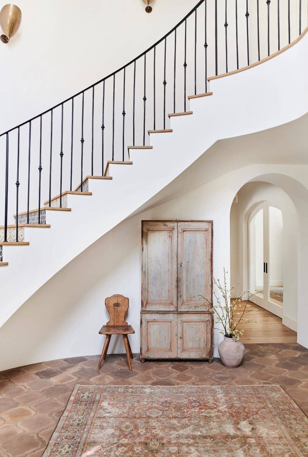 spanish style foyer with curved iron railing staircase