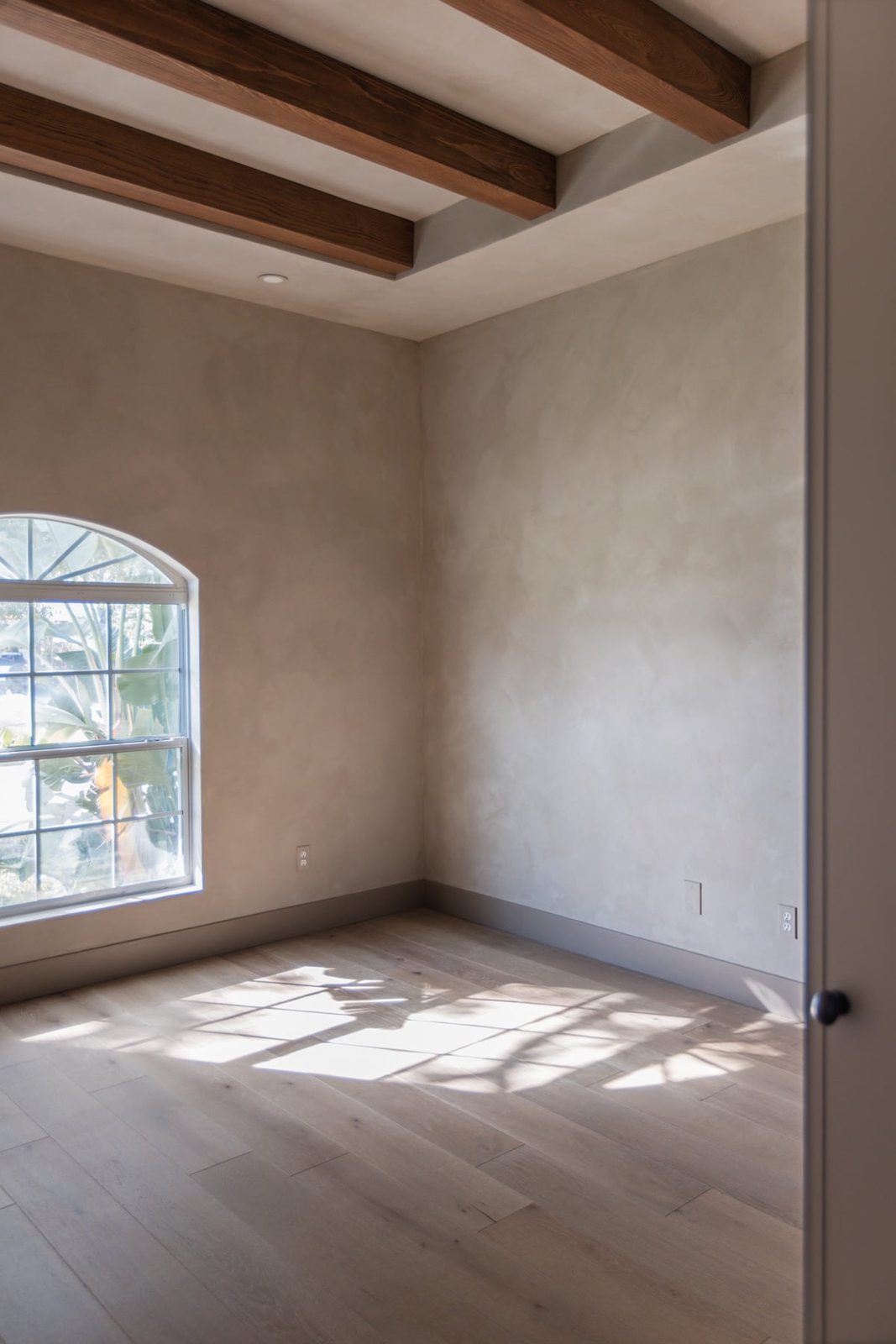 bedroom with lime wash and dark wood beams