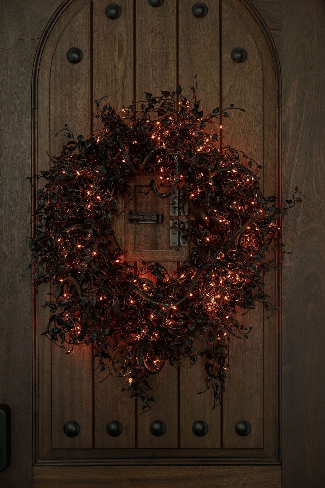 glowing halloween wreath with black ivy and snakes