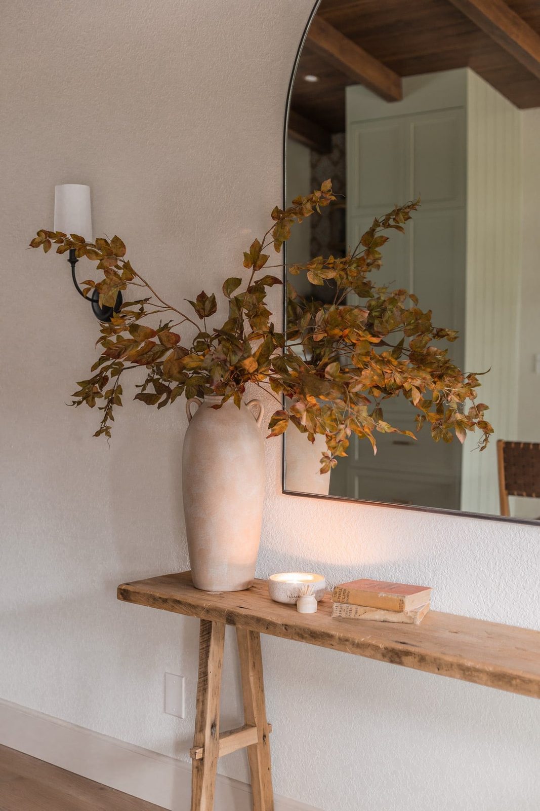 faux grape leaf fall branches in vase on console table
