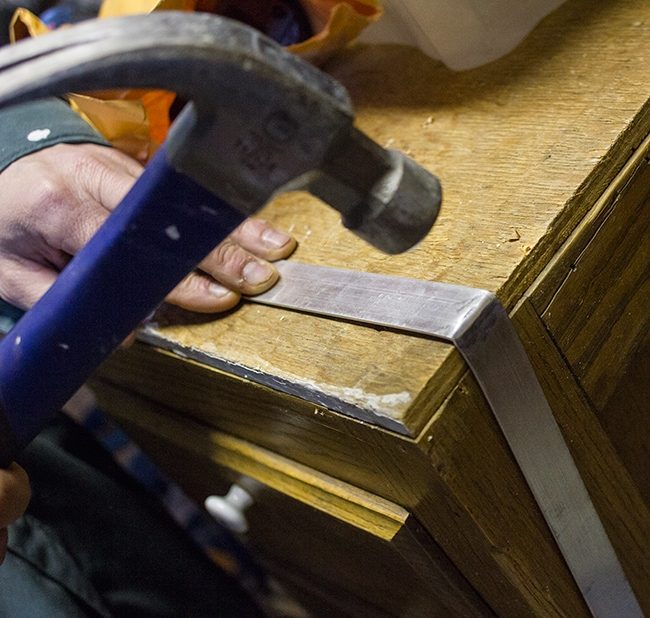 hammering metal straps to bend